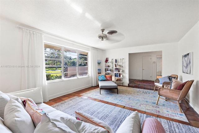 living room featuring ceiling fan and a textured ceiling