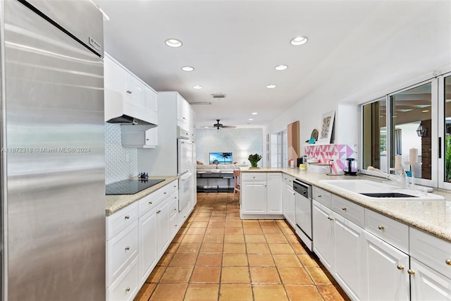 kitchen featuring sink, kitchen peninsula, white cabinetry, appliances with stainless steel finishes, and backsplash