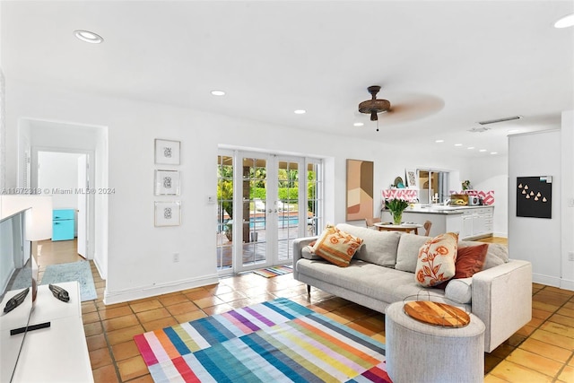 tiled living room featuring french doors and ceiling fan