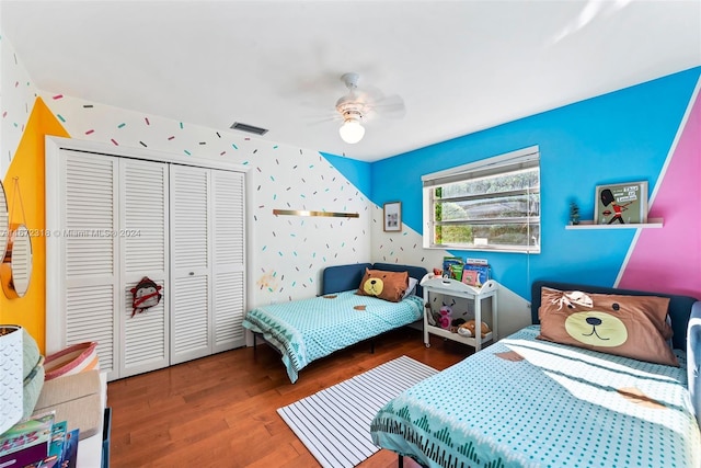 bedroom with ceiling fan, a closet, and dark hardwood / wood-style flooring