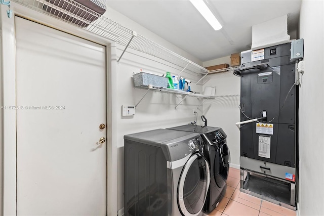 laundry room with washing machine and dryer, light tile patterned floors, and heating unit