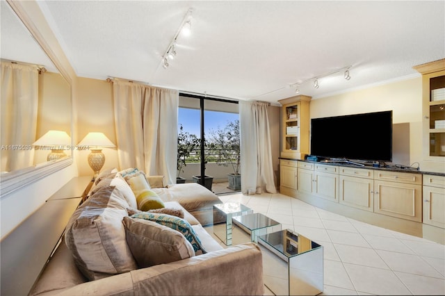 tiled living room featuring a textured ceiling, floor to ceiling windows, track lighting, and ornamental molding