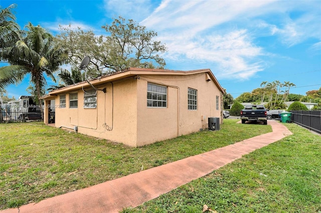 view of home's exterior featuring central AC unit and a lawn