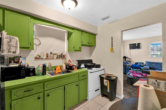 kitchen with green cabinetry, white range, and light tile patterned flooring