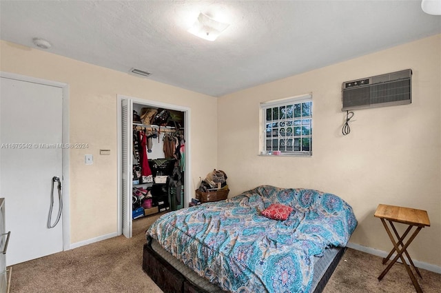 bedroom featuring carpet floors, a closet, a wall mounted air conditioner, and a textured ceiling