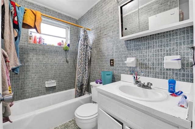 full bathroom with tile walls, shower / bath combo with shower curtain, vanity, and toilet