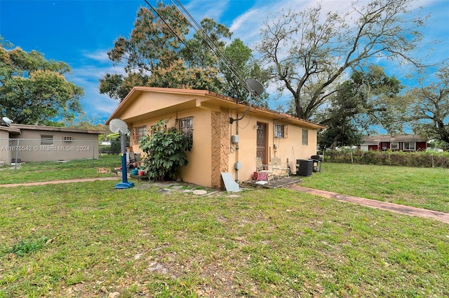 view of home's exterior with a lawn and central air condition unit