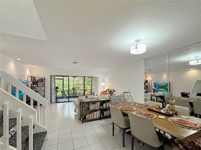 dining space featuring light tile patterned floors and a textured ceiling