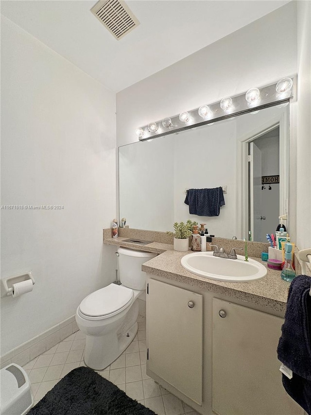 bathroom with tile patterned flooring, vanity, and toilet