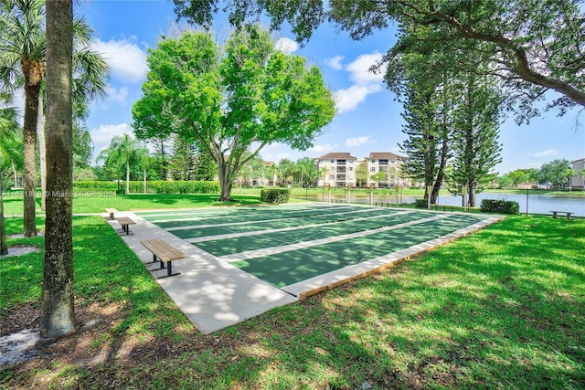 view of home's community featuring a water view and a yard