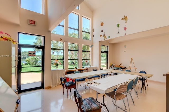 dining room featuring a high ceiling and plenty of natural light