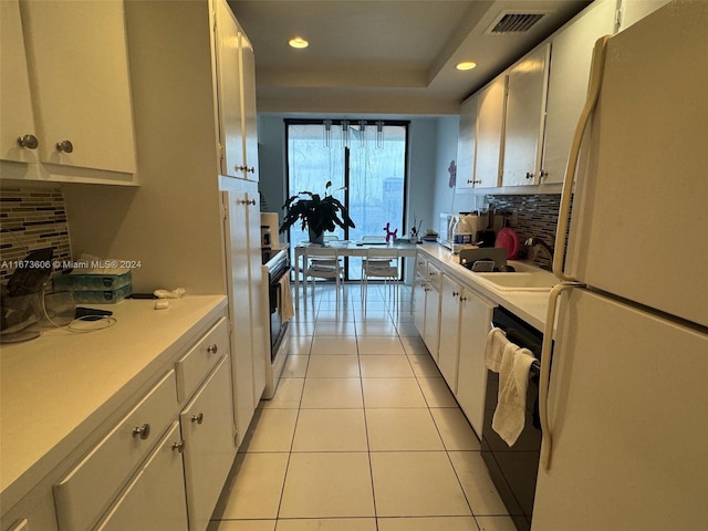 kitchen featuring black dishwasher, white refrigerator, and white cabinetry