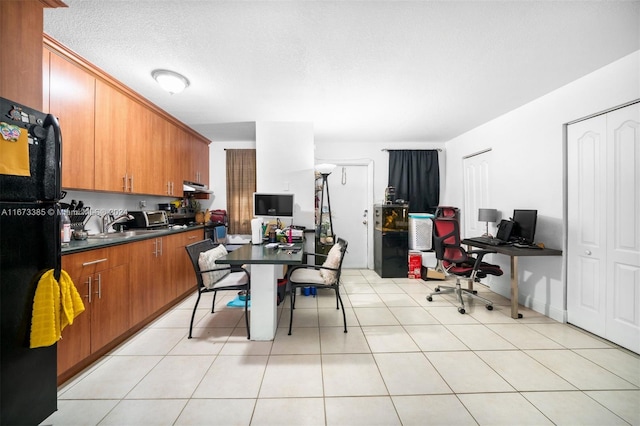 kitchen with black refrigerator and light tile patterned flooring