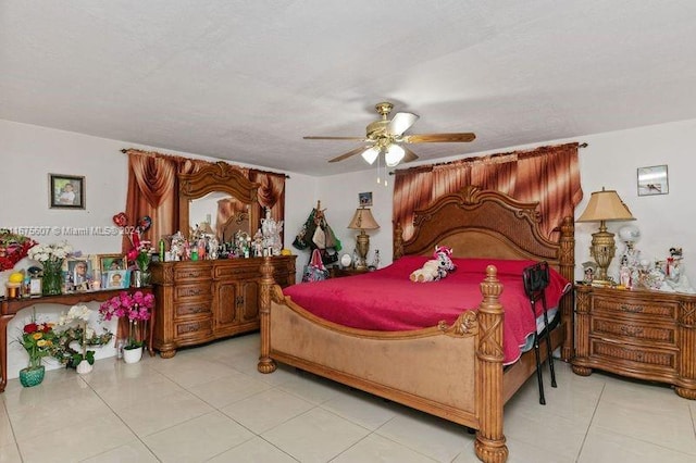 bedroom featuring a textured ceiling, light tile patterned floors, and ceiling fan