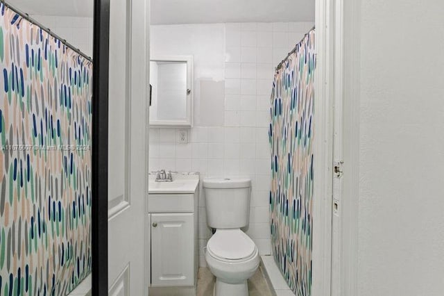 bathroom featuring vanity, tile walls, toilet, and curtained shower