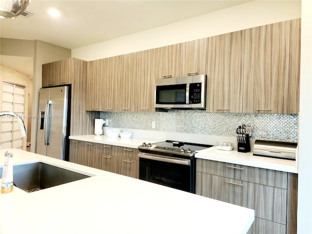 kitchen featuring tasteful backsplash, appliances with stainless steel finishes, sink, and light brown cabinets