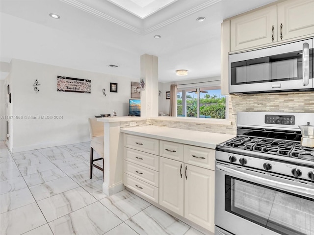 kitchen featuring decorative backsplash, kitchen peninsula, crown molding, a breakfast bar, and appliances with stainless steel finishes