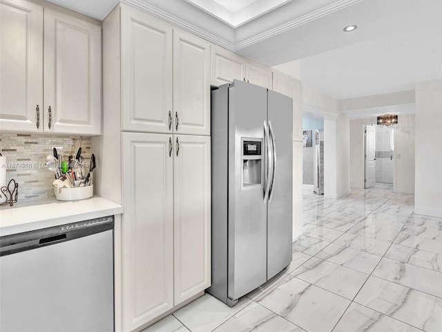 kitchen featuring stainless steel appliances, white cabinetry, decorative backsplash, and a notable chandelier