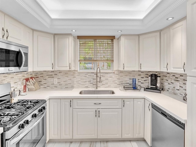 kitchen featuring appliances with stainless steel finishes, tasteful backsplash, sink, and a raised ceiling