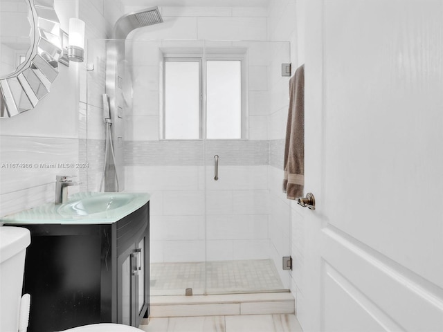 bathroom featuring toilet, vanity, and a shower with door