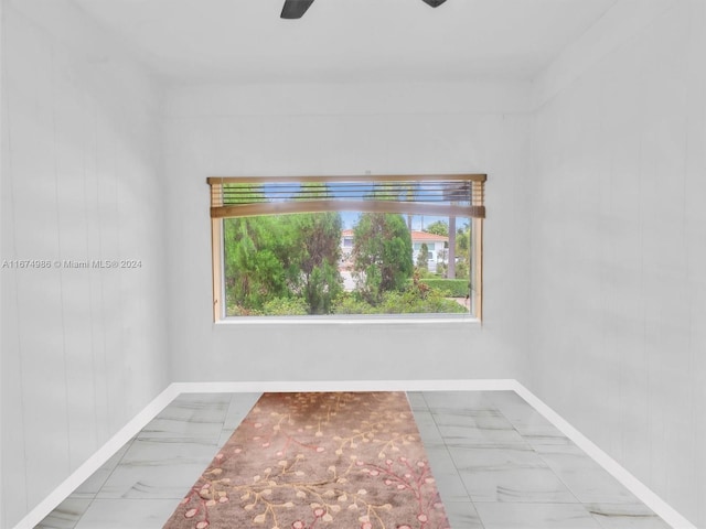 spare room with wooden walls and ceiling fan