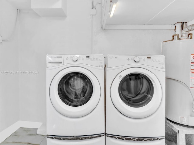 clothes washing area featuring water heater and washer and dryer