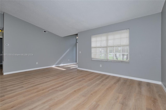 empty room featuring light hardwood / wood-style flooring and a textured ceiling