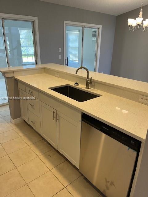 kitchen with sink, an inviting chandelier, dishwasher, hanging light fixtures, and light tile patterned flooring