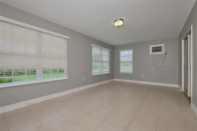 unfurnished room with light tile patterned floors and a wall mounted AC