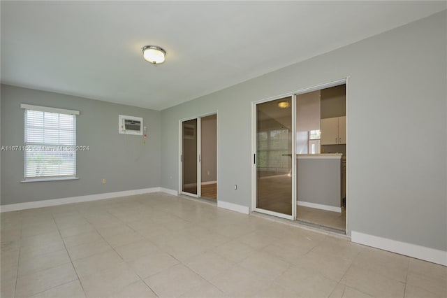 tiled spare room featuring an AC wall unit