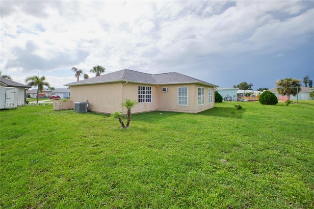 13592 Clara Ln, Port Charlotte, FL 33981 - back of house with central AC unit, stucco siding, and a yard