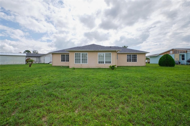 13592 Clara Ln, Port Charlotte, FL 33981 - rear view of property with stucco siding and a yard