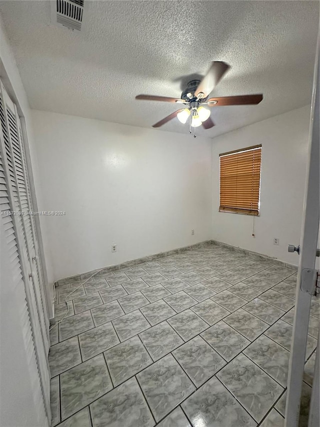 unfurnished bedroom with a closet, a textured ceiling, and ceiling fan