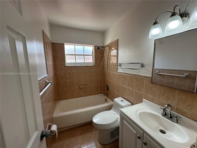 full bathroom with toilet, tile patterned floors, tile walls, vanity, and tiled shower / bath combo