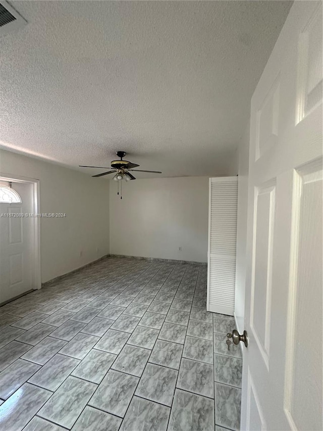 empty room featuring a textured ceiling and ceiling fan