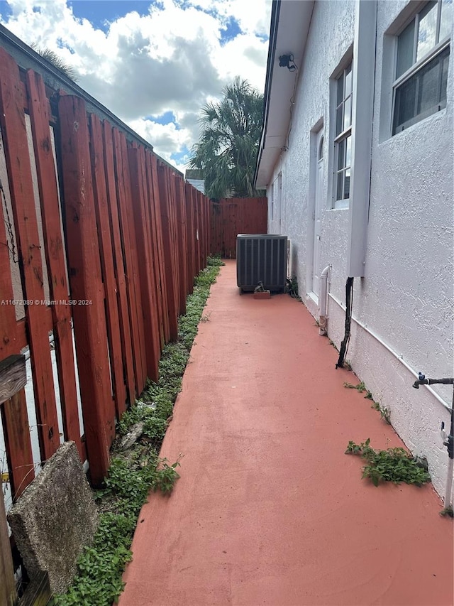 view of property exterior with a patio and central air condition unit