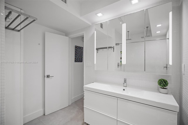 bathroom with tile patterned floors, visible vents, vanity, baseboards, and walk in shower