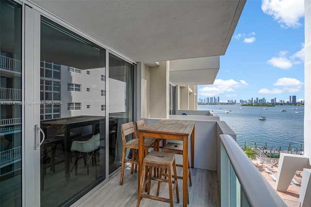 balcony featuring a city view and a water view