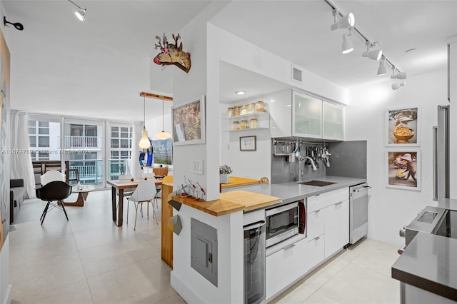 kitchen featuring a sink, track lighting, white cabinetry, appliances with stainless steel finishes, and visible vents