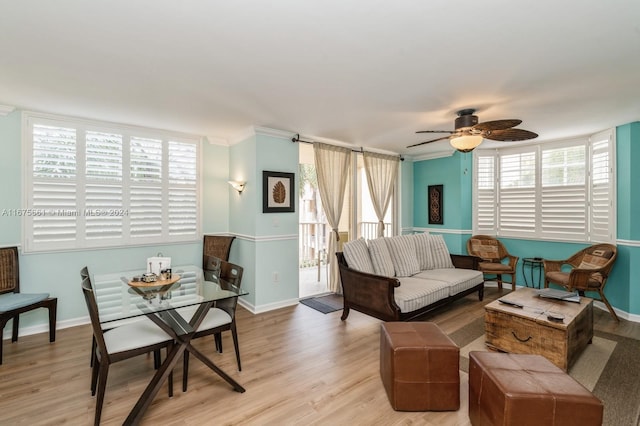 living room with light hardwood / wood-style floors, ornamental molding, a barn door, and ceiling fan