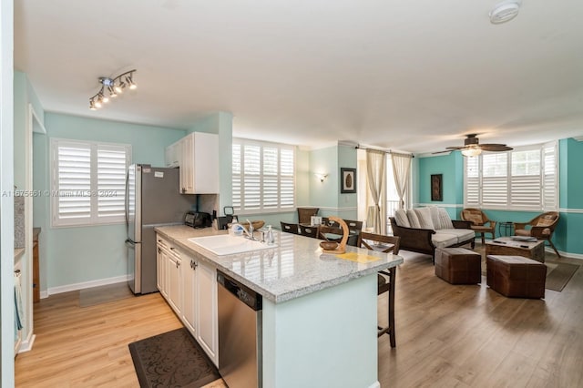 19655 E Country Club Dr Unit 6401, Aventura, FL 33180 - kitchen with stainless steel dishwasher, a sink, a kitchen breakfast bar, white cabinetry, and light wood-style flooring