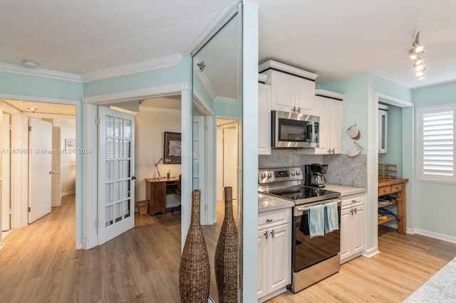 kitchen featuring crown molding, appliances with stainless steel finishes, light wood-type flooring, and white cabinets