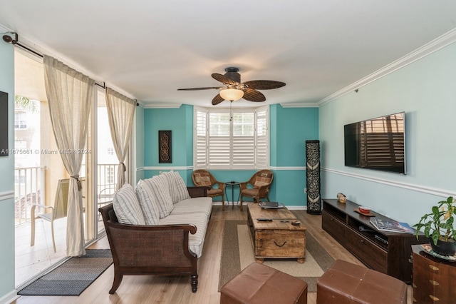 living room featuring ceiling fan, ornamental molding, and light wood-type flooring