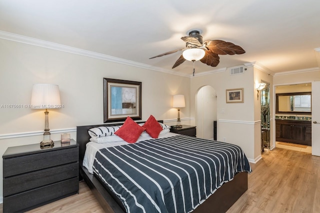 bedroom with light hardwood / wood-style floors, ornamental molding, ensuite bathroom, and ceiling fan