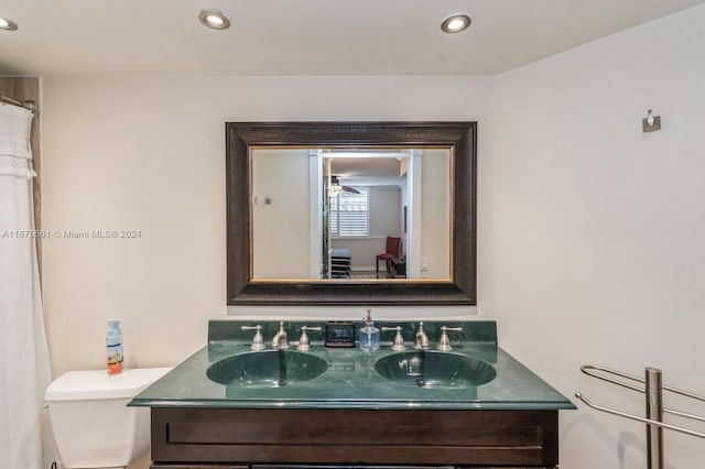 bathroom with vanity, toilet, and ceiling fan