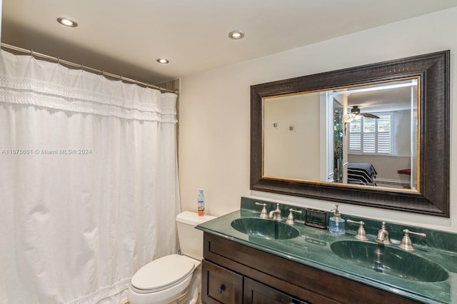 bathroom with toilet, vanity, and ceiling fan