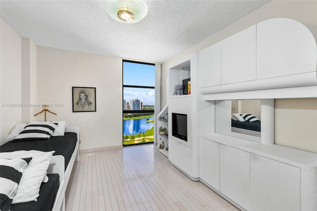 20281 E Country Club Dr Unit 1709, Aventura, FL 33180 - bedroom with baseboards, a textured ceiling, light wood-type flooring, and floor to ceiling windows