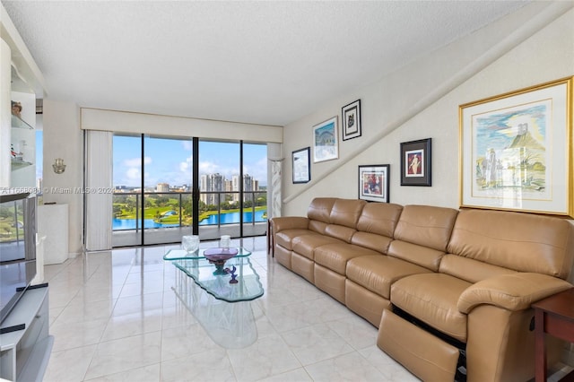 living room with a water view, light tile patterned floors, and a textured ceiling