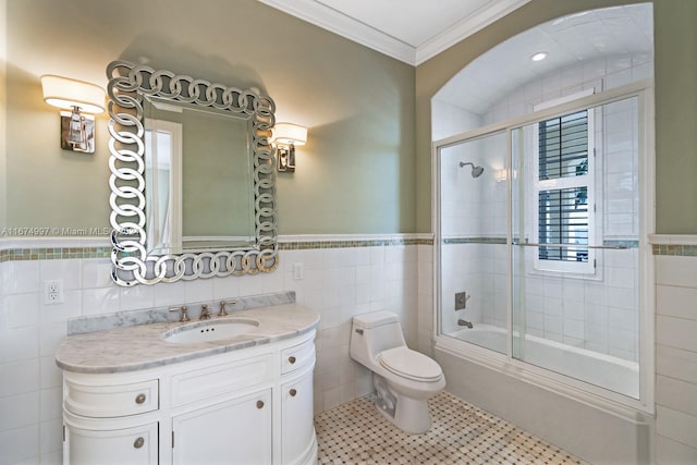 full bathroom with toilet, tile patterned flooring, vanity, tile walls, and shower / bath combination with glass door