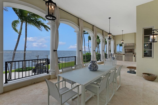 view of patio / terrace with a water view, a balcony, and exterior kitchen